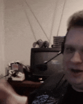 a man wearing a headset is smiling in front of a computer