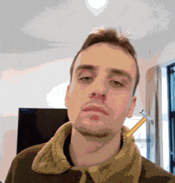 a man with a hammer sticking out of his ear looks tired