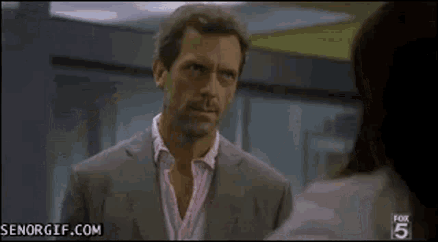 a woman in a white coat is talking to a man .