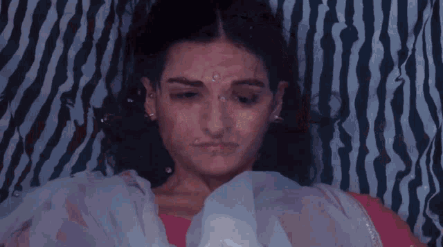 a woman is laying on a bed with a zebra print blanket behind her