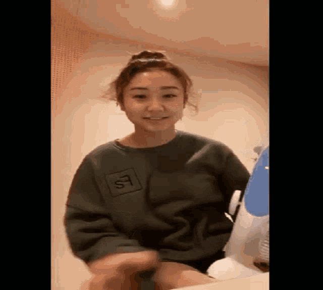 a woman wearing a green sweatshirt with the letter s on it