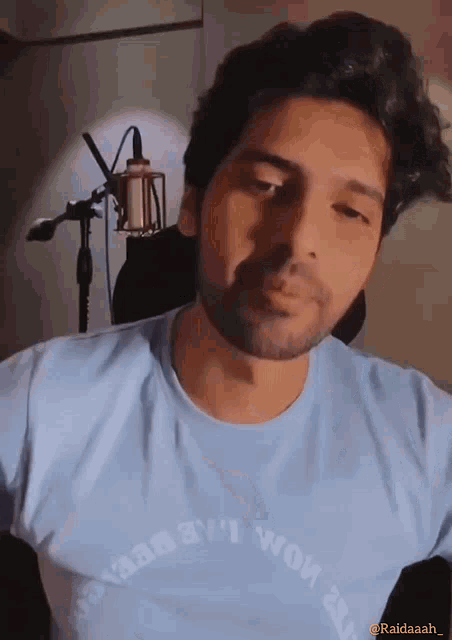 a man with a beard wearing a light blue t-shirt that says ' always ' on it