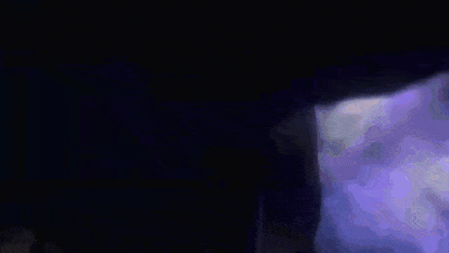 a purple and blue light is coming out of a dark room