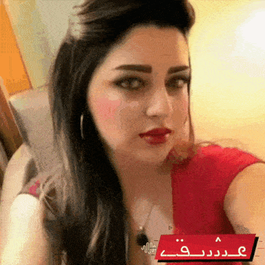 a woman in a red shirt is taking a selfie with a youtube logo in the corner