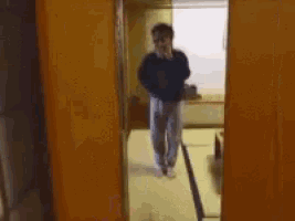 a blurry picture of a man taking a picture of another man in a hallway .