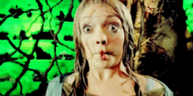a woman making a funny face with her mouth open in front of a green background