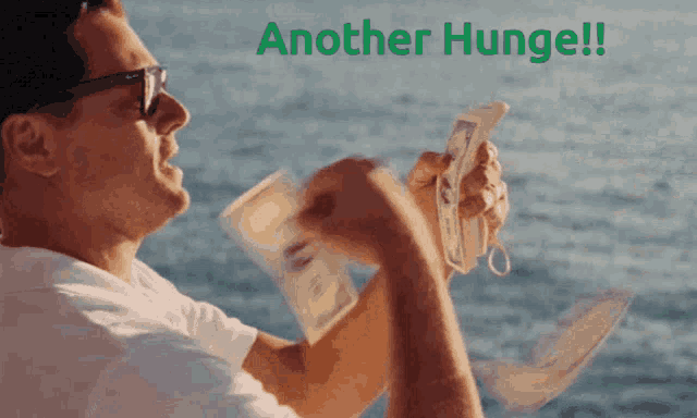 a man is holding a bunch of money and the words another hunger are visible behind him