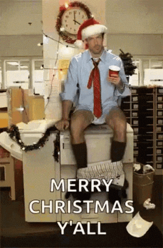 a man wearing a santa hat is sitting on a toilet holding a cup of coffee
