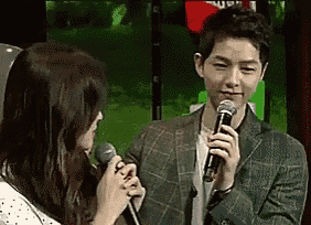 a man is holding a microphone next to a woman .