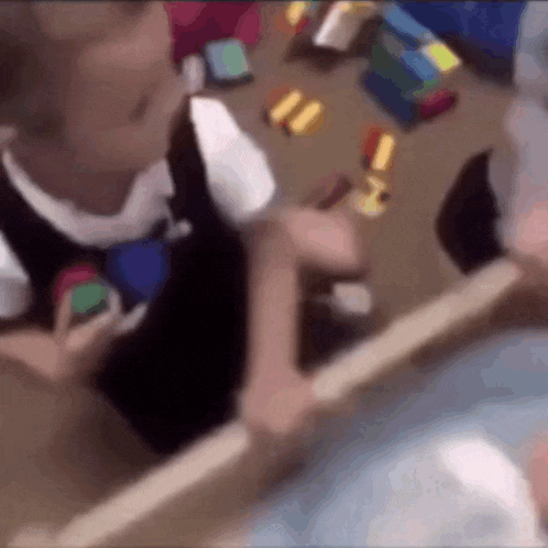 a blurry picture of a child playing with toys on the floor