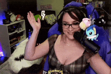a woman wearing glasses and headphones is sitting in front of a microphone .
