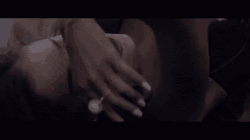 a close up of a woman laying on her stomach with her hands on her face .