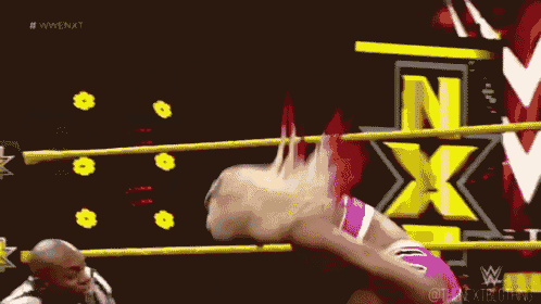 a woman is wrestling another woman in a wrestling ring while a referee looks on .