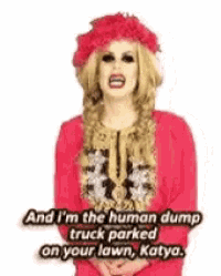 a drag queen is wearing a red shirt and a red hat with flowers in her hair .