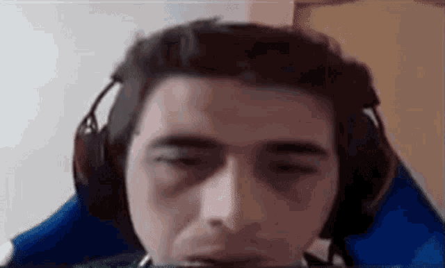 a man wearing headphones is sitting in a blue chair .
