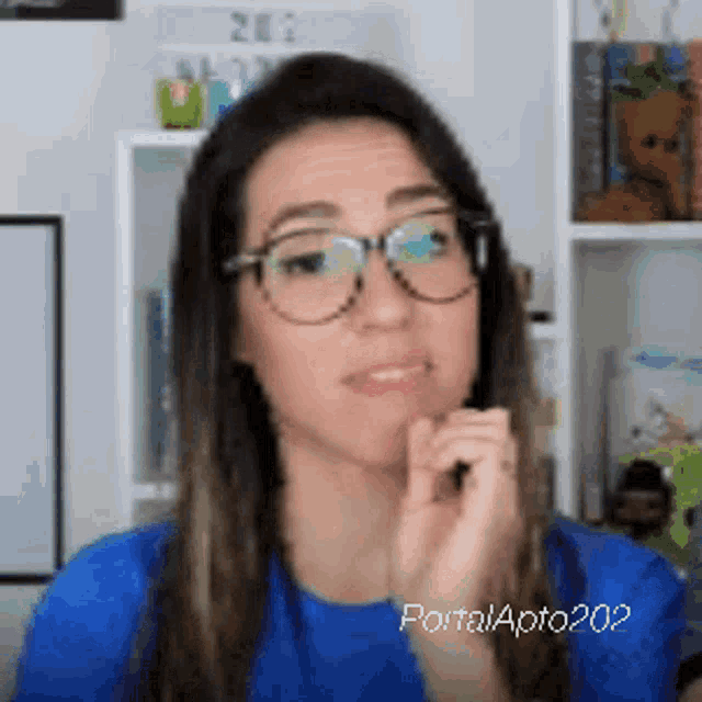 a woman wearing glasses and a blue shirt with portal apito202 written on the bottom