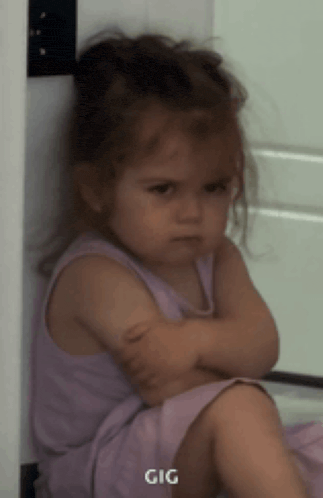 a little girl in a purple dress is sitting with her arms crossed and the word gig is on the bottom