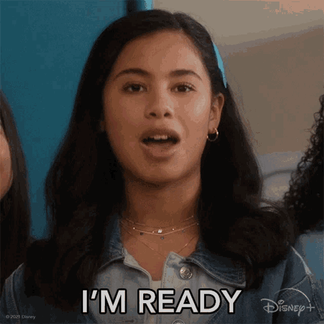 a girl says i 'm ready while wearing a denim jacket and earrings
