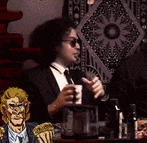 a man in a suit is sitting at a table holding a cup of coffee