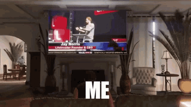 a man is sitting in front of a television with the words me on the screen