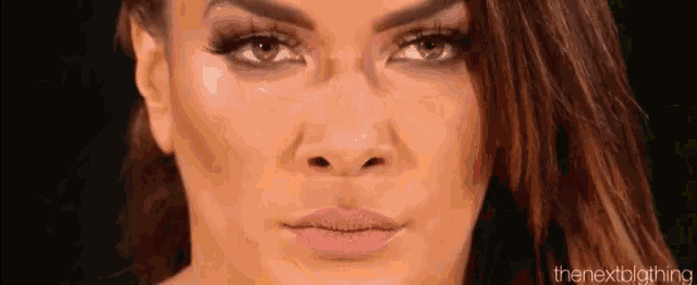 a close up of a woman 's face with a black background and a pink lip .