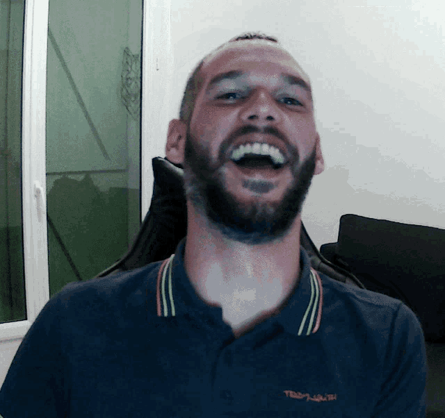 a man with a beard wearing a polo shirt that says ted baker on it