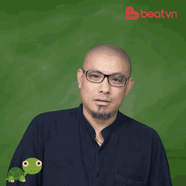 a man with glasses and a beard is standing in front of a green background with a beatvn logo in the corner