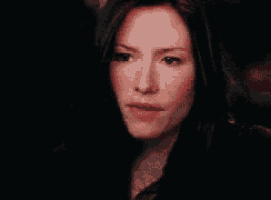 a close up of a woman 's face with long dark hair .