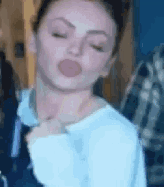 a close up of a woman making a funny face with her eyes closed and her tongue out .