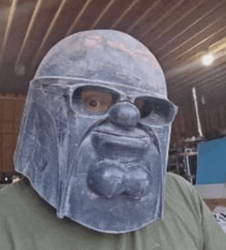 a man wearing a helmet with a face on it and glasses .