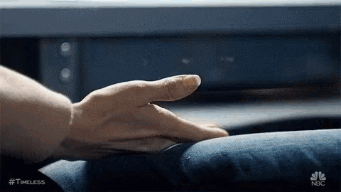 a close up of a person 's hand touching a chair .