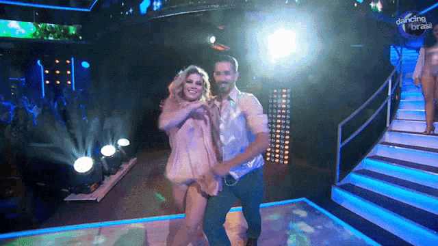 a man and a woman are dancing on a stage with dancing break written on the bottom of the screen