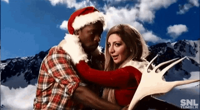 a man in a santa hat is hugging a woman