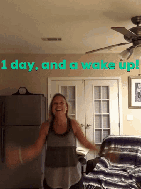 a woman dancing in front of a wall that says 1 day and a wake up