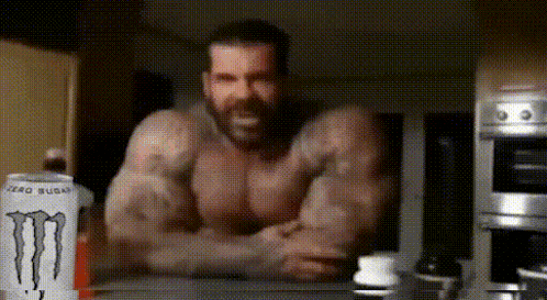 a man is sitting at a table with a can of monster energy drink in front of him