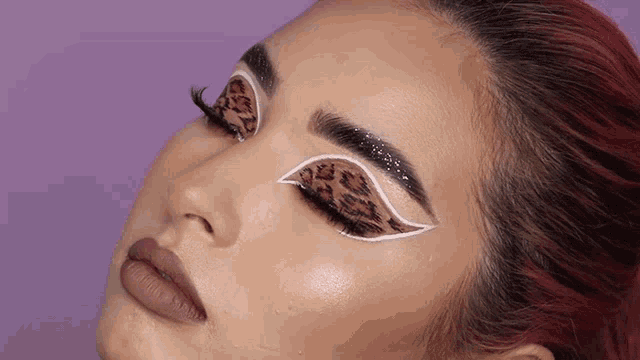 a close up of a woman 's face with a leopard print on her eye