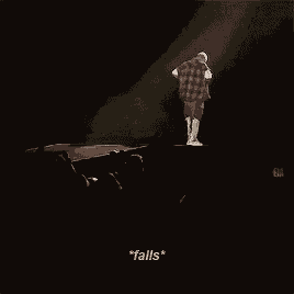 a man in a plaid shirt is singing into a microphone on a stage while a crowd watches ..