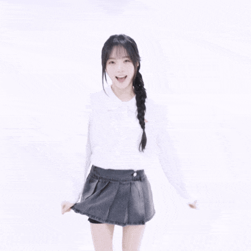 a girl with braided hair wearing a white shirt with a red embroidered logo