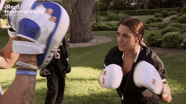a woman wearing boxing gloves is standing next to a man with the number 5 on his shirt