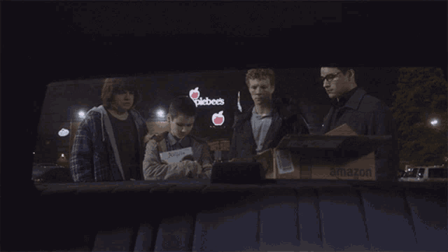 a group of people are standing in front of an applebee 's sign