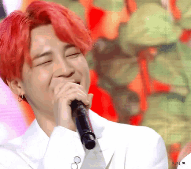 a man with red hair is holding a microphone to his mouth