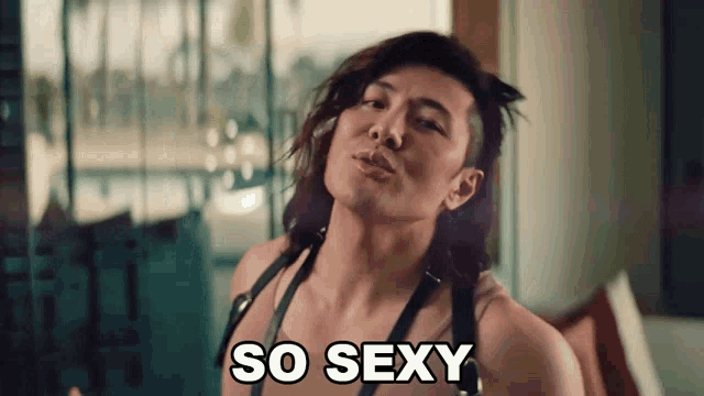 a man with long hair says so sexy while wearing a harness