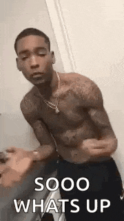a shirtless man is standing in front of a door and talking to someone .