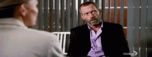 a man in a suit and purple shirt is talking to a woman .