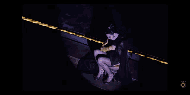 a woman in a black cape is sitting next to a man