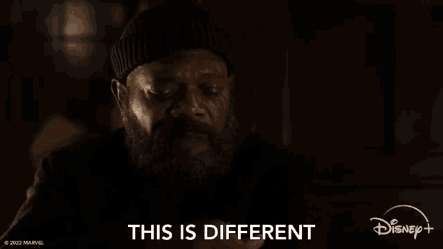 a man with a beard is sitting in a dark room with his eyes closed and says `` this is different '' .