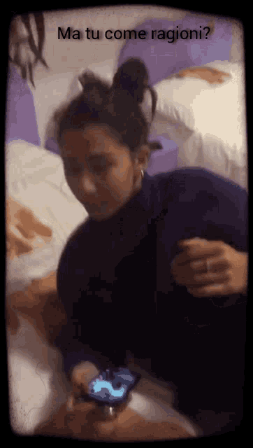 a woman laying on a bed looking at her phone with the words ma tu come ragione