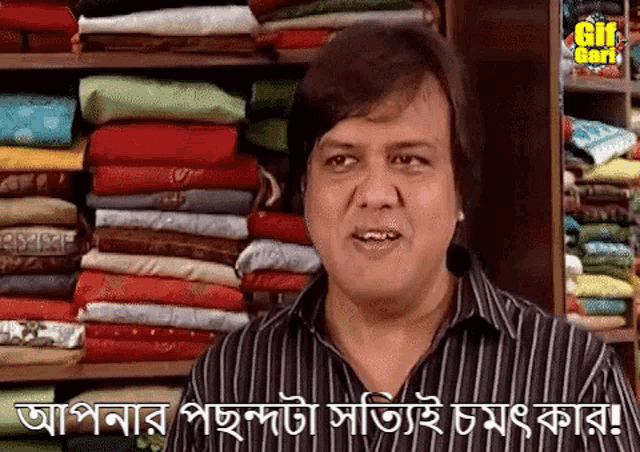 a man in a striped shirt stands in front of a stack of clothes and says " gif god "