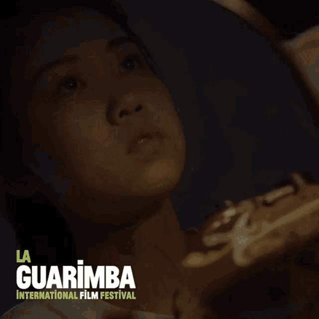 a poster for the la guarimba international film festival shows a person looking through binoculars
