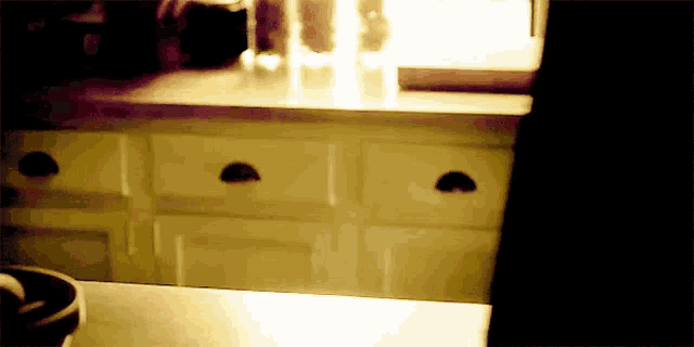 a kitchen counter with a few drawers and a window behind it